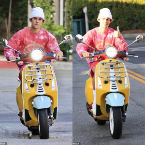 Justin Bieber spreads good vibes as he flashes a thumbs up while riding around LA on his yellow Vespa