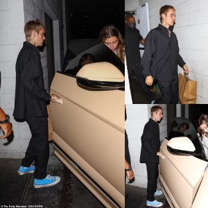 Justin Bieber cuts a casual figure in all-black while his wife Hailey opts for a chic grey suit as they head home after a dinner date in LA